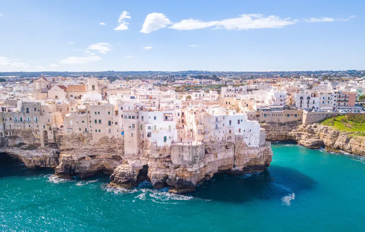 Panorami mozzafiato: case bianche aggrappate alle scogliere, mare turchese. Un assaggio di cosa vedere in Puglia, un sogno ad occhi aperti.