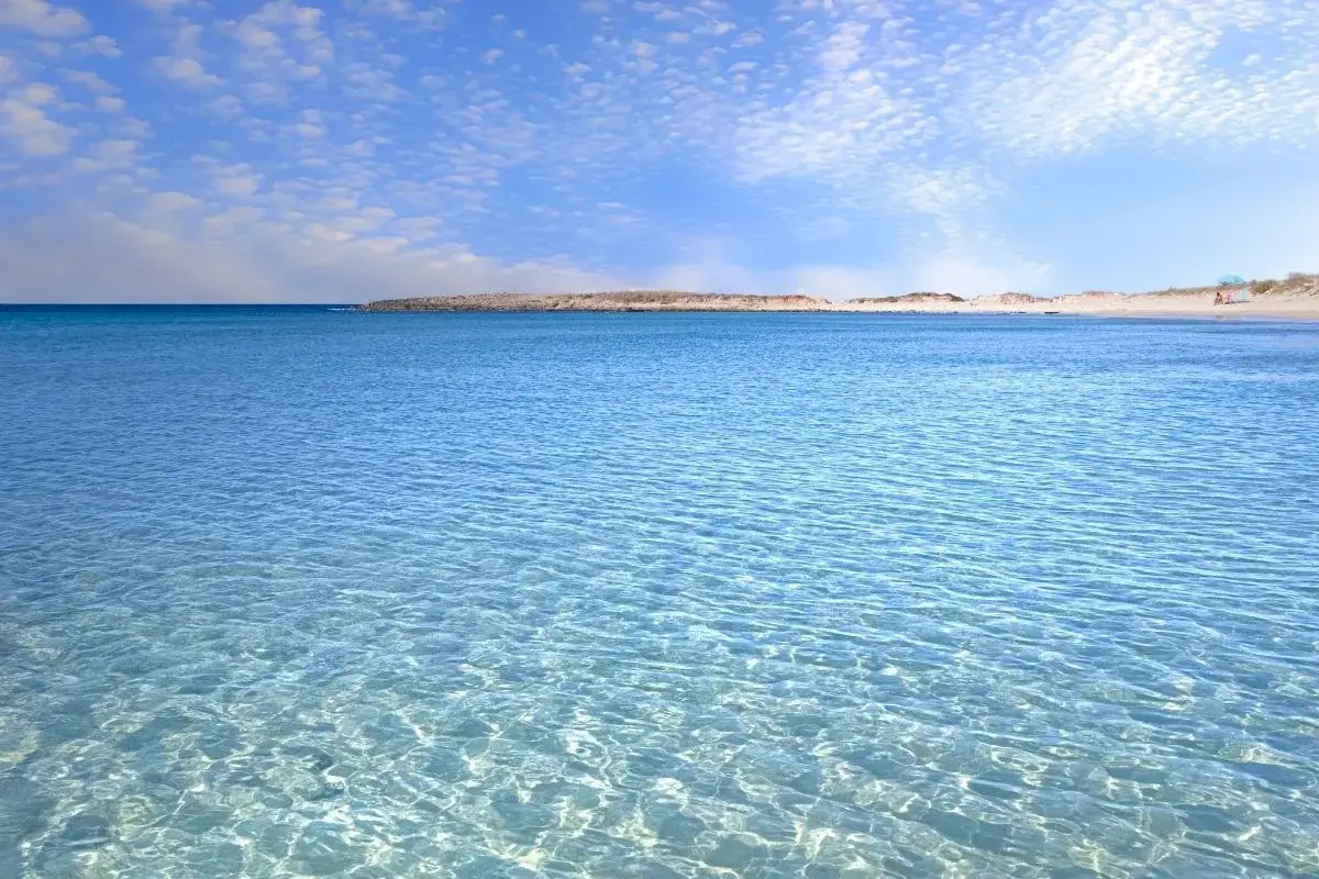 Acque cristalline e cielo azzurro con nuvole leggere, un invito a rilassarsi in questo splendido lido marini.