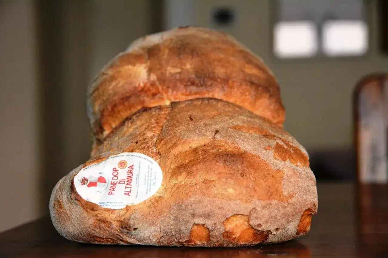 Pane tipico pugliese, il pane DOP di Altamura, con la sua crosta dorata e la mollica soffice, pronto per essere gustato.