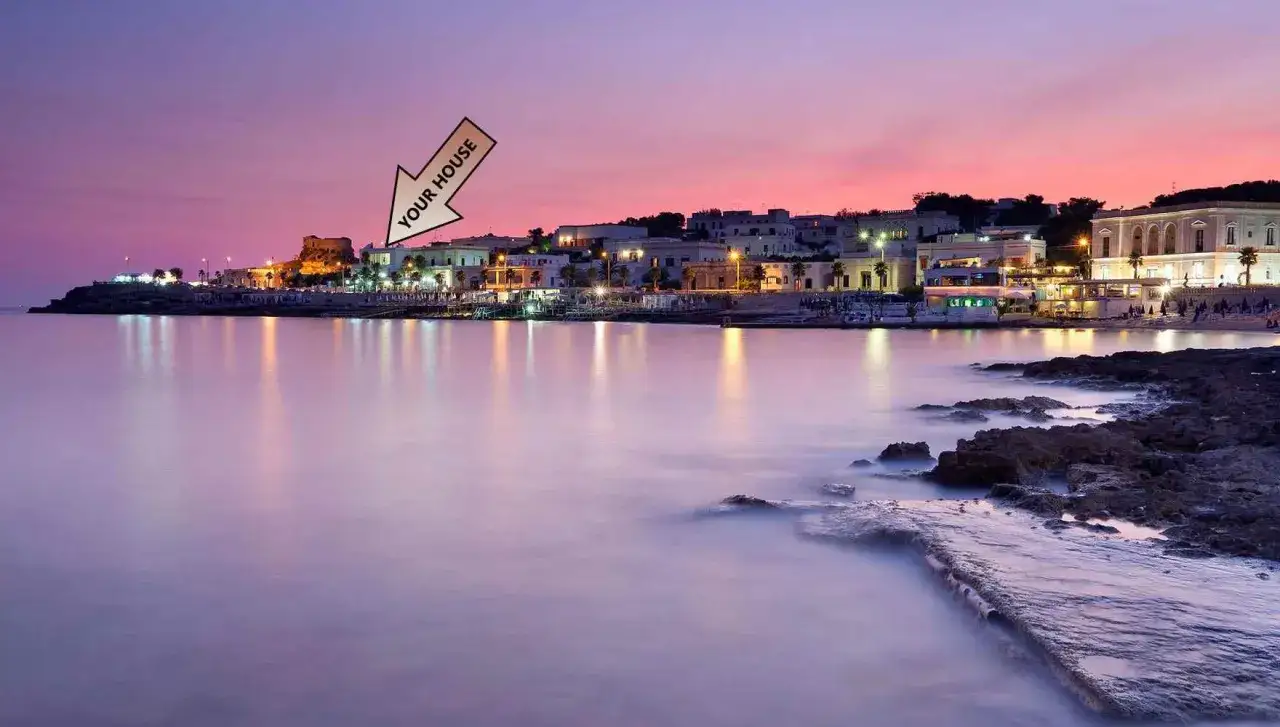 Il lungomare di Santa Maria di Leuca al tramonto, con le luci della città che si riflettono sul mare calmo. La tua casa è lì, in quella vista incantevole.
