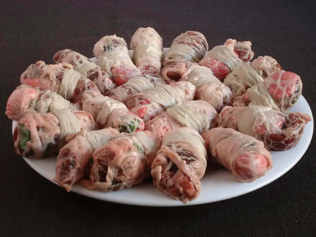 Piatto di involtini di interiora pugliesi, preparati con cura e legati con sottili fili di grasso.
