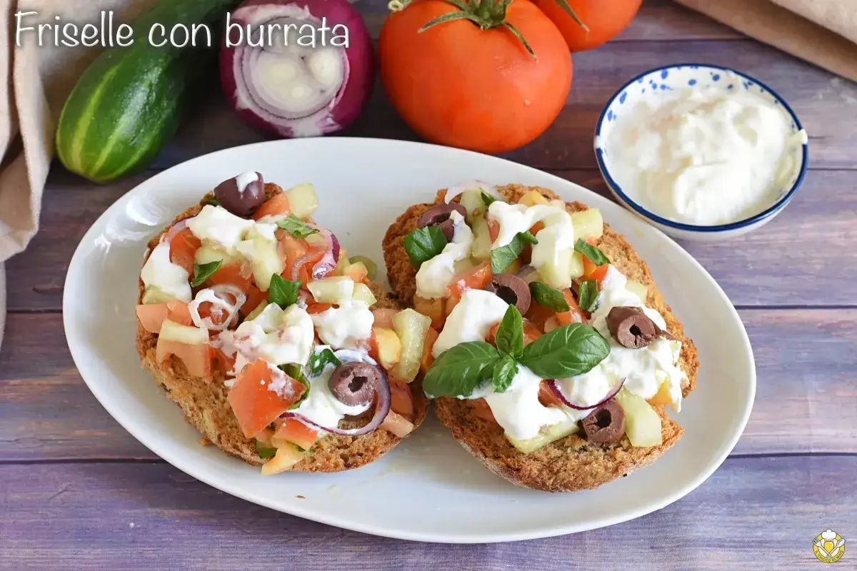 Friselle con burrata, un piatto che celebra i prodotti tipici pugliesi: pomodori, cetrioli, cipolla rossa, olive e basilico fresco.