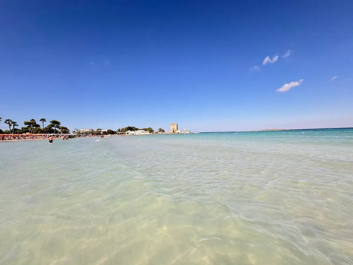 Acque cristalline e una torre antica a Sant Isidoro, Salento. Un angolo di paradiso per godersi il sole e il mare.
