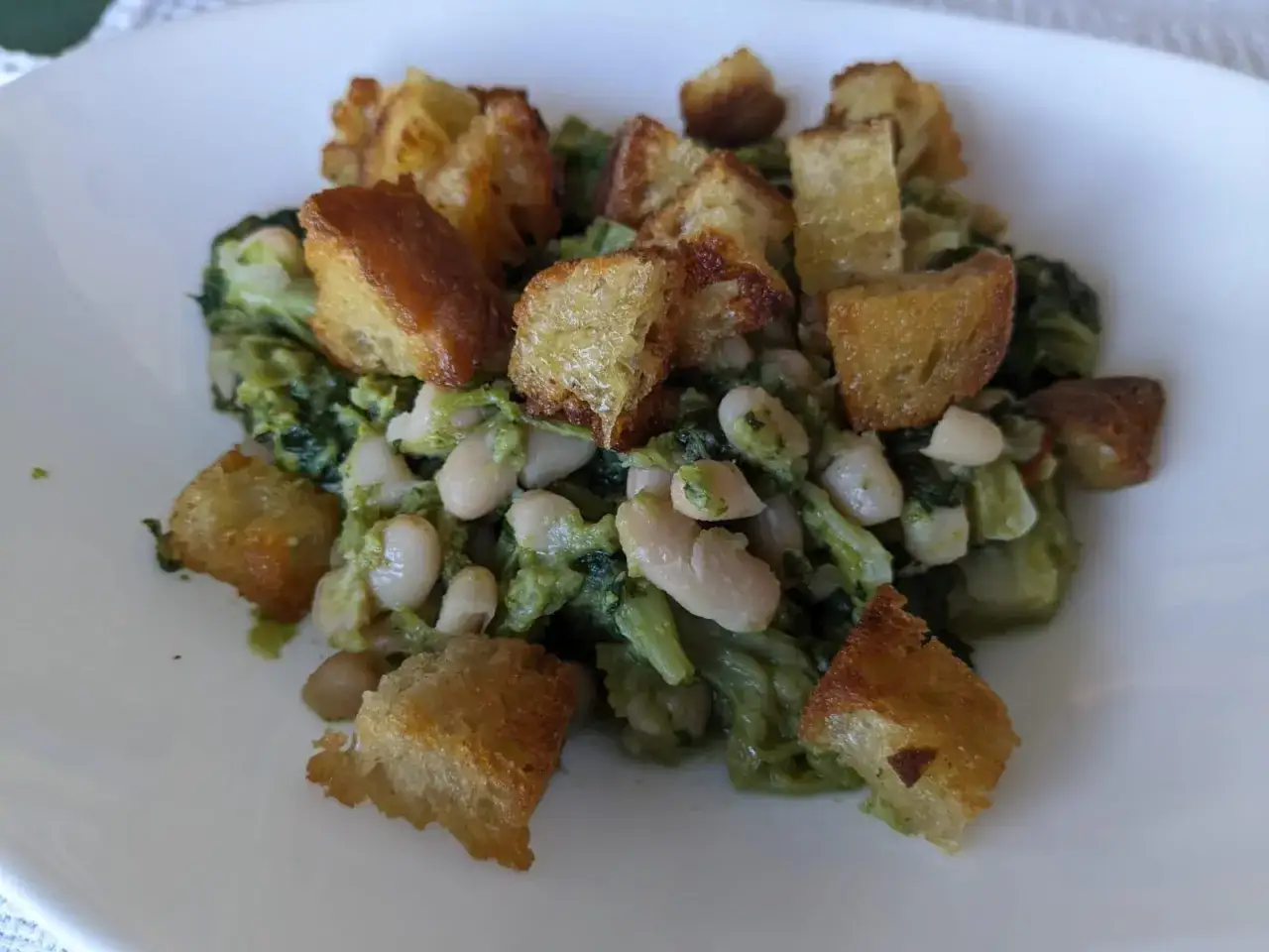 Un piatto di verdure verdi, fagioli bianchi e crostini dorati. Un vero marenna, che significa spuntino o pasto leggero, perfetto per una pausa gustosa.