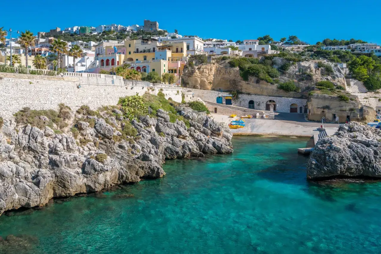 Un'idea per dove andare a Pasquetta in Puglia: un borgo bianco su una scogliera a picco sul mare cristallino, con piccole spiagge e grotte.