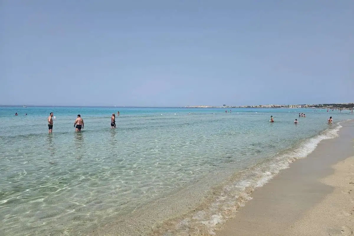Persone in acqua cristallina, un assaggio de le spiagge pi&ugrave; belle di Gallipoli.