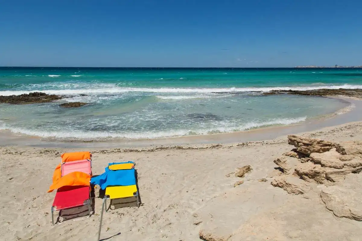 Spiagge pi&ugrave; belle di Gallipoli: lettini colorati su sabbia dorata, mare cristallino e rocce scolpite dal vento.
