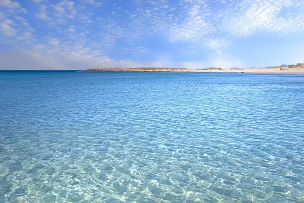 Acque cristalline e cielo azzurro con nuvole leggere, un invito a rilassarsi in questo splendido lido marini.